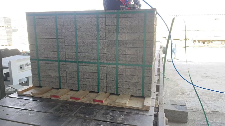 Concrete block package being strapped after automatic cubing
